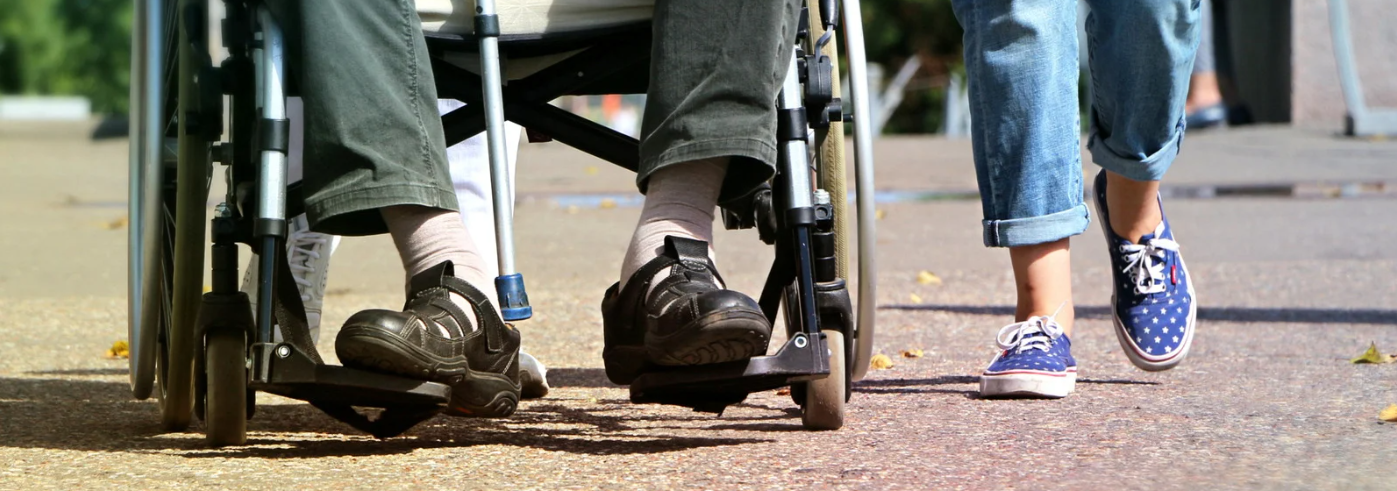Acompañado Imagen de los pies de una niña que acompaña a un adulto que va en silla de ruedas